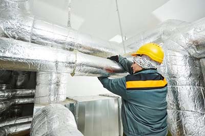 Un calorifugeur travaillant avec divers types de matériaux isolants.